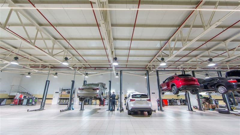 Interior del taller mecánico Catabois Motor en Ferrol con vehículos en los elevadores